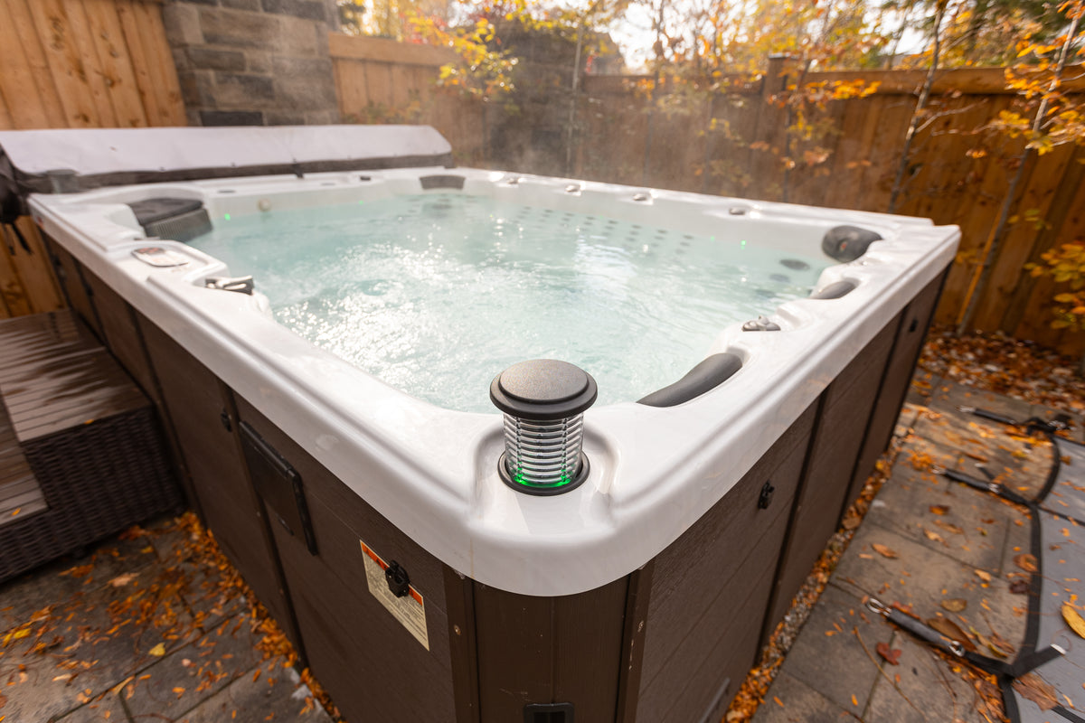 A Canadian Spa hot tub in a garden with autumn foliage
